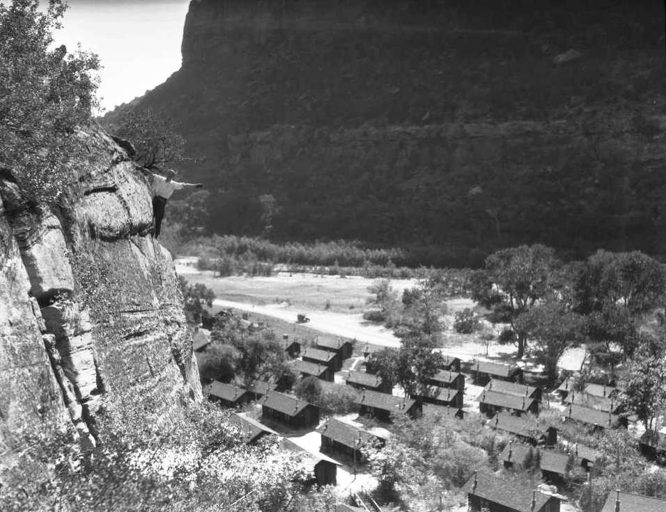 Vincent H. Hunter, Union Pacific photographer, points toward cabins and the lodge in Zion National Park